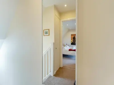 a door leading into a bedroom with a bed at Kestrel Cottage - 27937 in Stirling