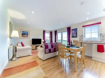a kitchen and living room with a table and chairs at Osprey Cottage- 27939 in Stirling
