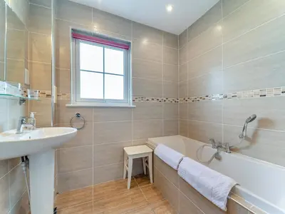 a bathroom with a tub and a sink and a bath tub at Osprey Cottage- 27939 in Stirling