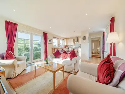 a living room with white furniture and red curtains at Buzzard Cottage - 27940 in Stirling