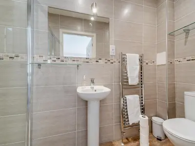 a bathroom with a sink and a shower and a toilet at Buzzard Cottage - 27940 in Stirling