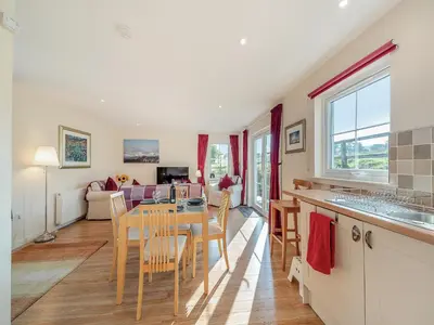 a kitchen and living room with a table and chairs at Buzzard Cottage - 27940 in Stirling