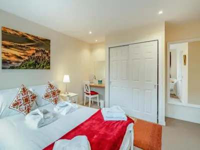 a bedroom with a white bed with a red blanket at Barn Owl Cottage - 27941 in Stirling