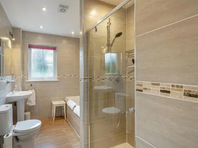 a bathroom with a shower and a toilet and a sink at Barn Owl Cottage - 27941 in Stirling