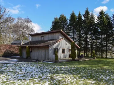 a small wooden building in a yard with trees at Inzievar in Oakley