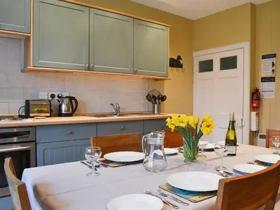 a kitchen with a table with plates and flowers on it at Old Inzievar in Blairhall