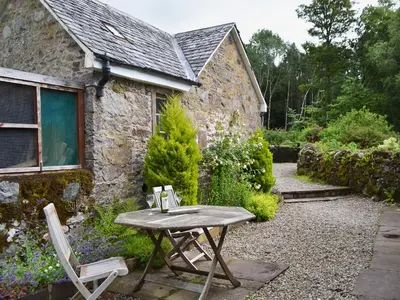 a table and chairs in front of a stone house at Westerton Lodge - Srrh in Crieff