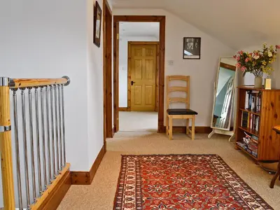 a hallway with a radiator and a door and a rug at Rathlin Coach House in Comrie