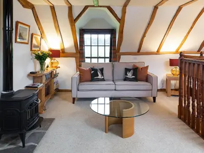 a living room with a couch and a stove at Fochy Cottage in Milnathort