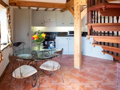 a kitchen with a glass table and chairs at The Hayloft in Milnathort