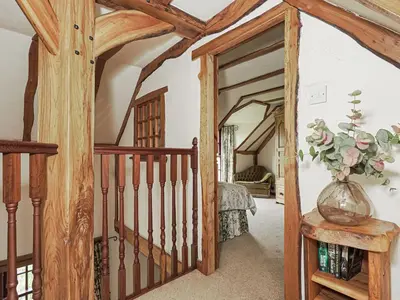 a room with a staircase and a vase of flowers on a table at The Hayloft in Milnathort