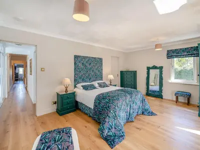 a bedroom with a large bed and a wooden floor at Tigh Na Beannaich in Powmill
