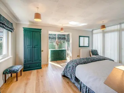 a bedroom with a green bed and a window at Tigh Na Beannaich in Powmill