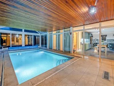 a swimming pool in a house with a wooden ceiling at Tigh Na Beannaich in Powmill