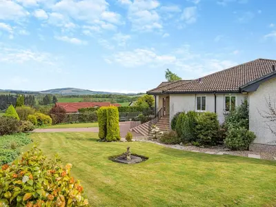 a house with a yard with a grassy yard at Tigh Na Beannaich in Powmill