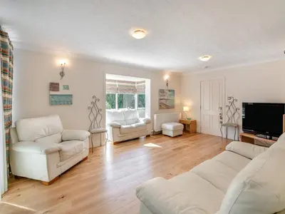 a living room with white furniture and a flat screen tv at Tigh Na Beannaich in Powmill