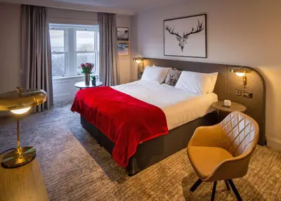 a hotel room with a bed and a chair at Bruntsfield Hotel in Edinburgh