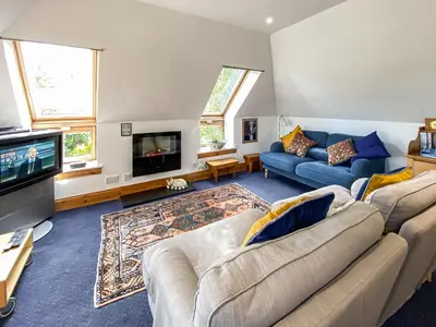 a living room with two couches and a tv at Garden Cottage in Linlithgow