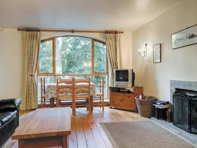 a living room with a couch and a table and a television at Coach House in Ratho