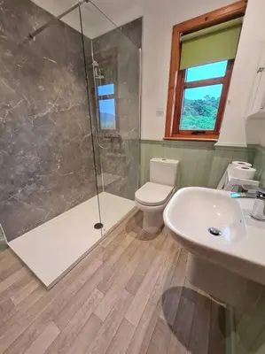 a bathroom with a shower and a toilet and a sink at Kings Reach - Dunadd Cottage in Lochgilphead