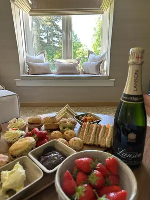 a table with a plate of food and a bottle of beer at Gleneagles Holiday Home Rental in Auchterarder