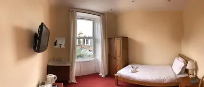 a small room with a bed and a window at Cruachan Guest House in Edinburgh