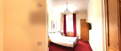 a bedroom with a bed and a room with a window at Cruachan Guest House in Edinburgh