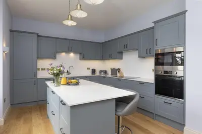a kitchen with blue cabinets and a white counter top at East Wing in Thornhill