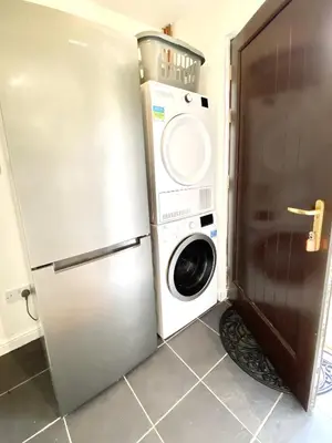 a washer and dryer in a kitchen next to a refrigerator at Lochindaal - Beautiful, Spacious 4 Bedroom House in Kintyre in Whitehouse