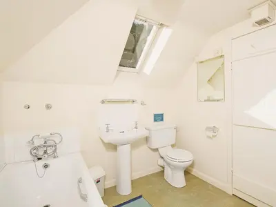 a white bathroom with a toilet and a sink at Gardener's Cottage-Uxt in Corsock