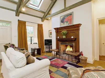 a living room with a fireplace and a white couch at Stables Cottage-Uud in Corsock