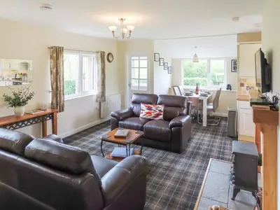 a living room with a couch and a table at Swallow Lodge in Carsphairn