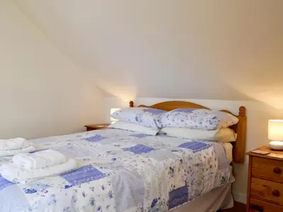 a bedroom with a bed with towels on it at Kirsty Cottage in Moffat