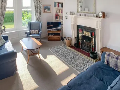 a living room with a couch and a fireplace at Dunmaghlas in Pirnmill
