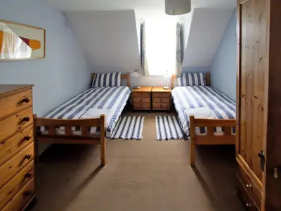 a attic room with two beds and a dresser at Dunmaghlas in Pirnmill