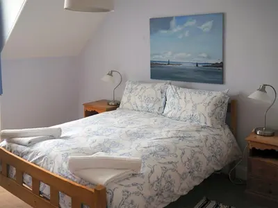 a bedroom with a bed and two lamps and a painting at Dunmaghlas in Pirnmill