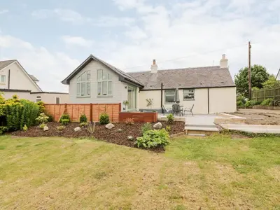 a house with a garden in front of it at Braeface Cottage in Bonnybridge