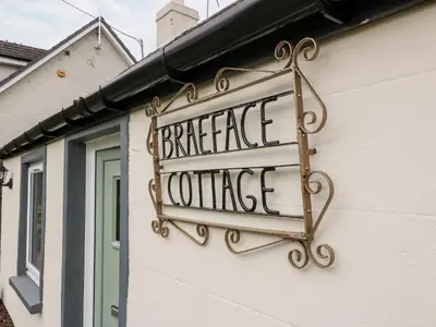 a sign on the side of a building at Braeface Cottage in Bonnybridge