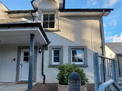a white house with a white door and windows at Taigh Geal in Killin