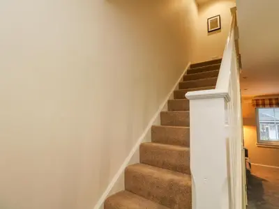 a stairway in a home with brown carpet at Taigh Geal in Killin