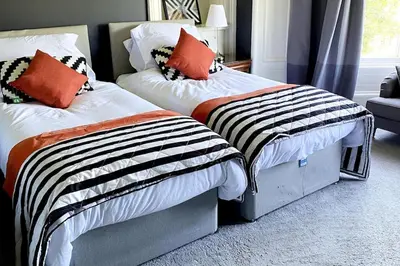 two beds sitting next to each other in a bedroom at Stunning 3 bedroom Victorian home near Pollok country park in Glasgow