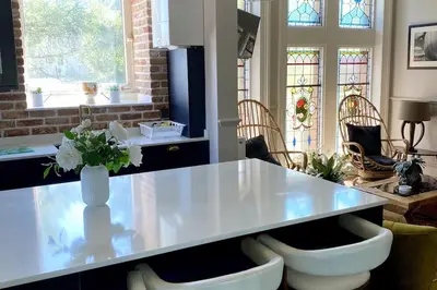 a kitchen with a counter with a vase of flowers at Stunning 3 bedroom Victorian home near Pollok country park in Glasgow