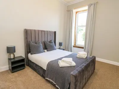 a bedroom with a large bed with two towels on it at Mars Hill Upper in Dunoon