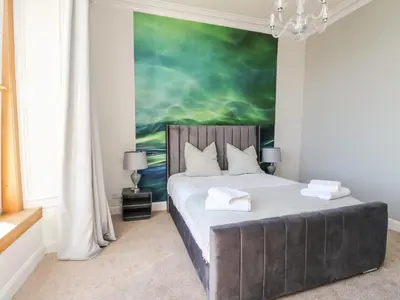 a bedroom with a bed with a painting on the wall at Mars Hill Upper in Dunoon
