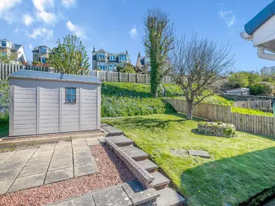 a garden with a small shed in a yard at Seamill Cottage in Seamill