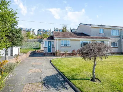 a house with a yard with a tree at Seamill Cottage in Seamill