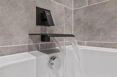 a bath tub with a faucet and a sink at The Riverside Rest 1 in Stirling