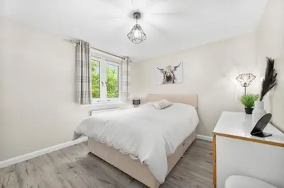 a white bedroom with a bed and a window at The Riverside Rest 1 in Stirling