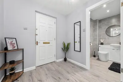 a bathroom with a white door and a toilet at The Riverside Rest 1 in Stirling