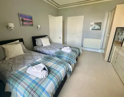a bedroom with two beds with towels on them at Bayside - Breathtaking views of the Clyde in Rothesay